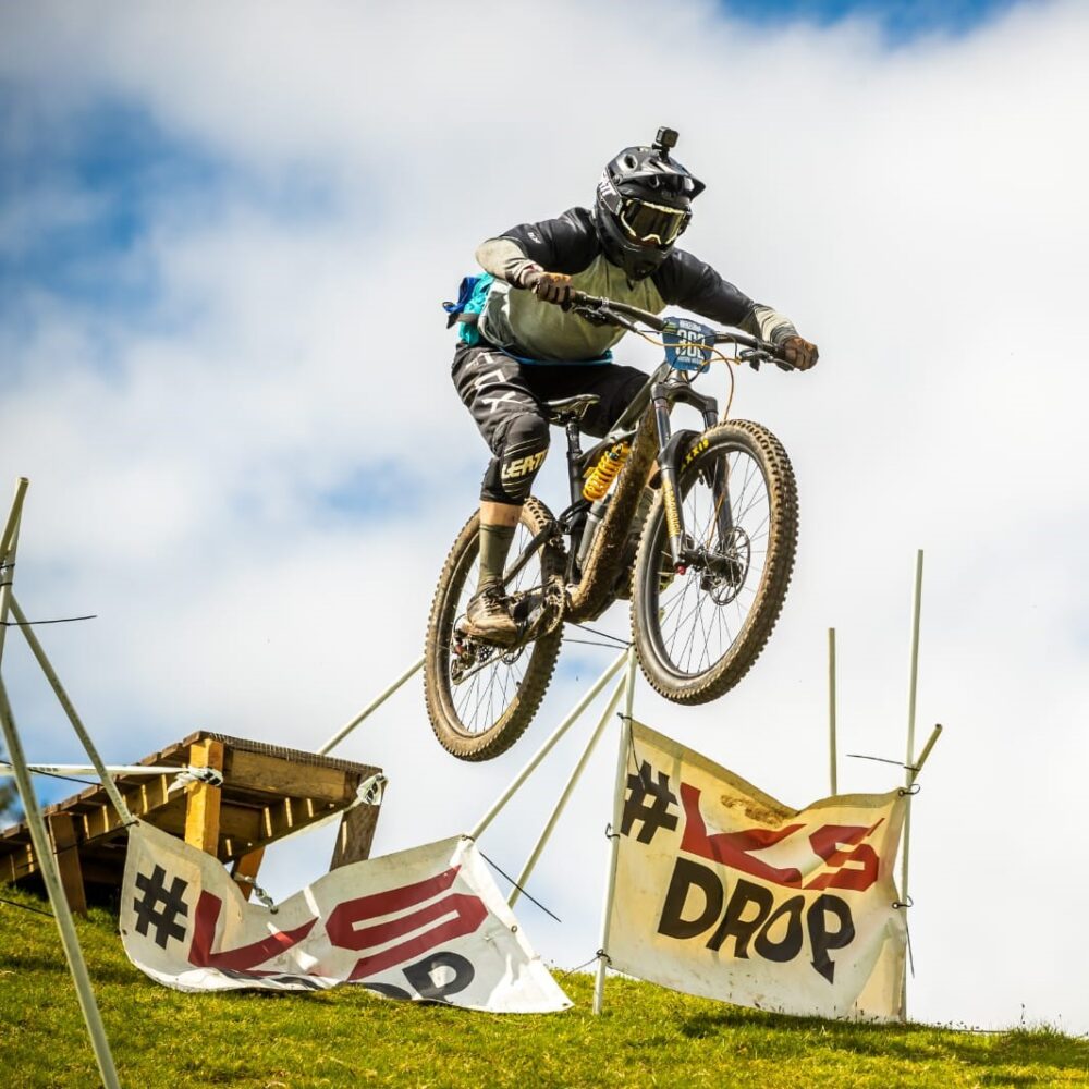 Downhill mountain bike rider jumping, UK