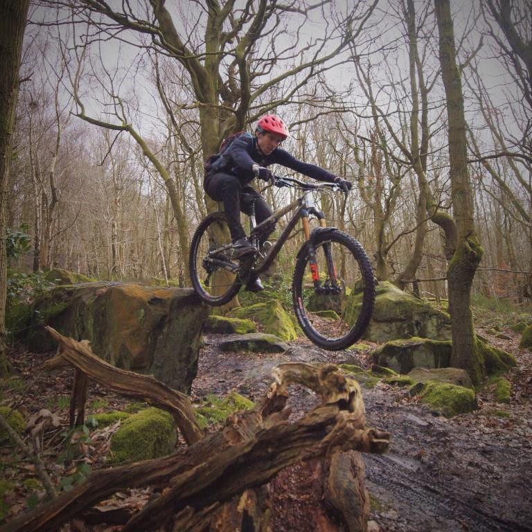 Mountain bike rider learning to do a drop, Wharncliffe Woods, Yorkshire