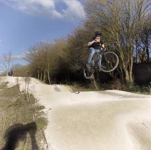 MTB rider learning mountain bike jumps, Grenoside Woods, Sheffield, Yorkshire